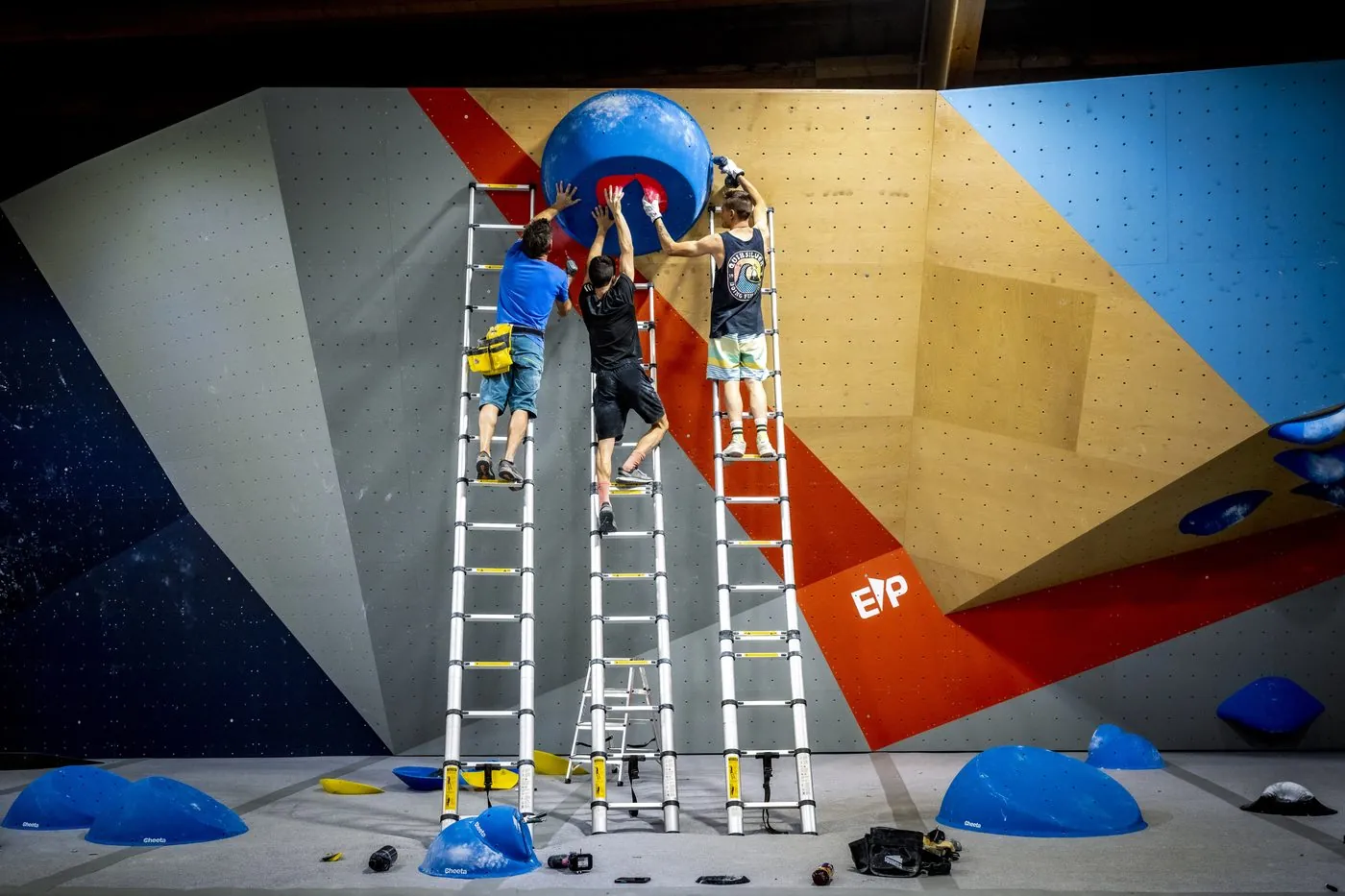 Three setters on ladders install a route